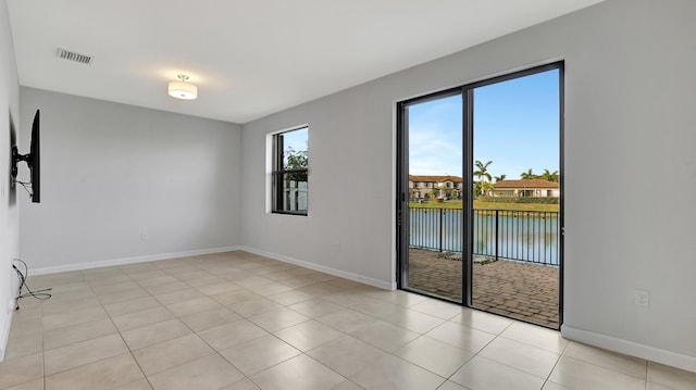 tiled spare room with a water view