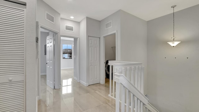 hallway with a healthy amount of sunlight and light tile patterned floors