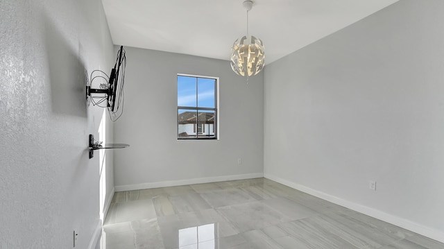 spare room with a chandelier