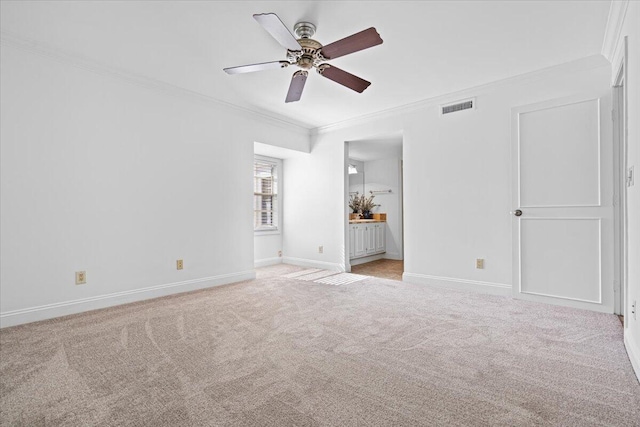 unfurnished bedroom with ceiling fan, light colored carpet, ornamental molding, and ensuite bathroom