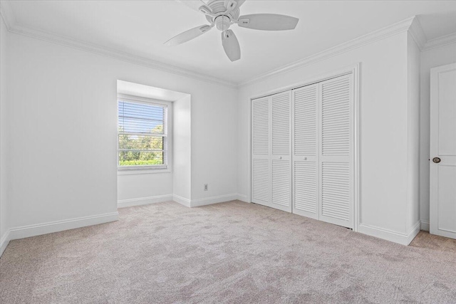 unfurnished bedroom with a closet, light colored carpet, ceiling fan, and ornamental molding