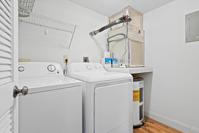 washroom with washer and clothes dryer, electric panel, and light hardwood / wood-style flooring