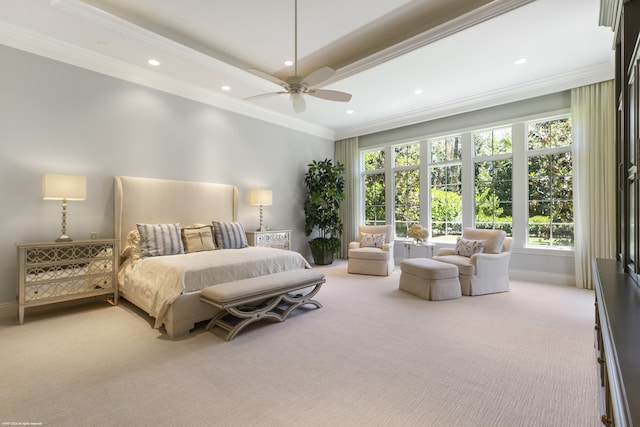 carpeted bedroom featuring a tray ceiling, ceiling fan, and crown molding