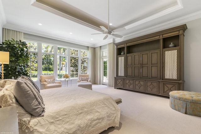 carpeted bedroom with a raised ceiling, ceiling fan, and ornamental molding