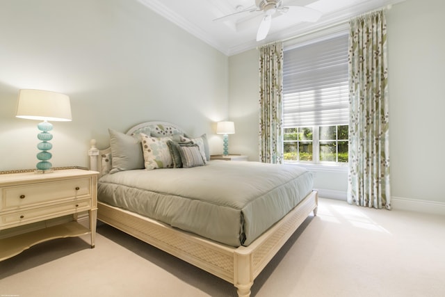 carpeted bedroom featuring ceiling fan and crown molding