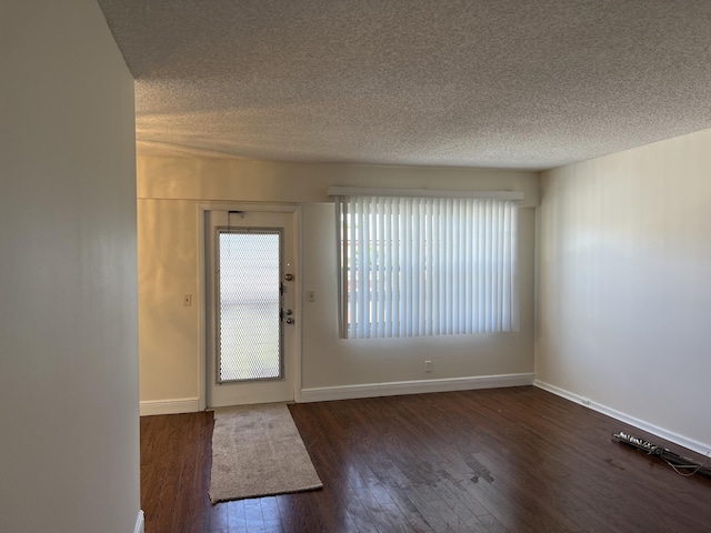 entryway with a textured ceiling and dark hardwood / wood-style floors