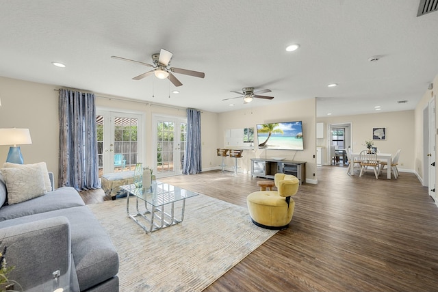 living room with hardwood / wood-style flooring, ceiling fan, a textured ceiling, and french doors