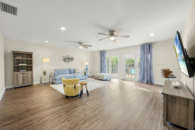 living room with ceiling fan, hardwood / wood-style floors, and a textured ceiling