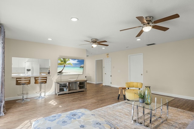 living room with light hardwood / wood-style floors and ceiling fan