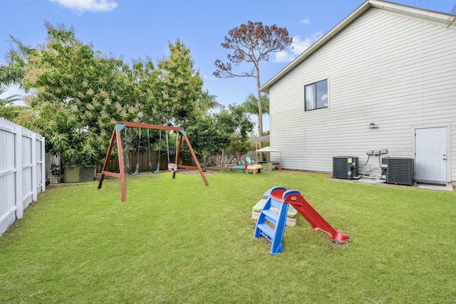 view of jungle gym featuring a lawn and central AC unit