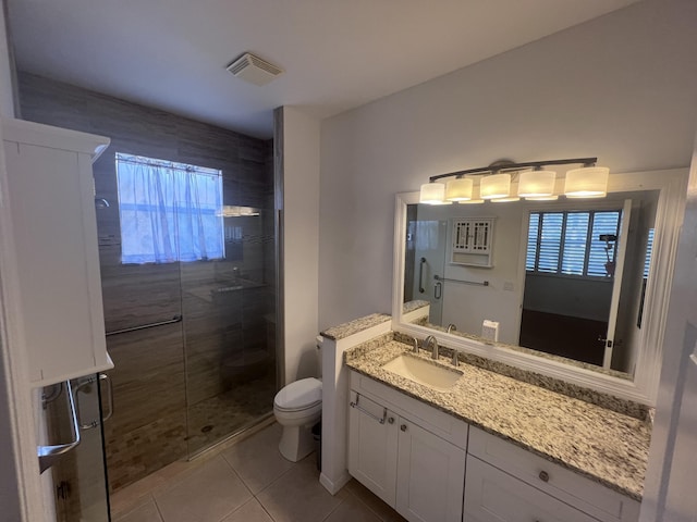 bathroom with tile patterned flooring, vanity, toilet, and a shower with door