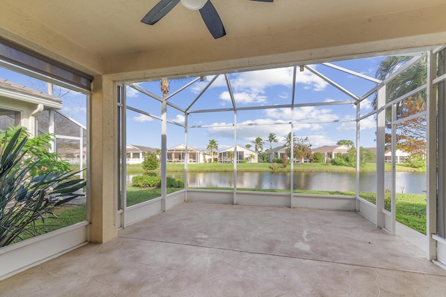 unfurnished sunroom with ceiling fan and a water view