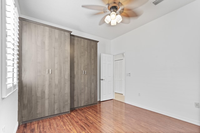 unfurnished bedroom featuring ceiling fan and dark wood-type flooring