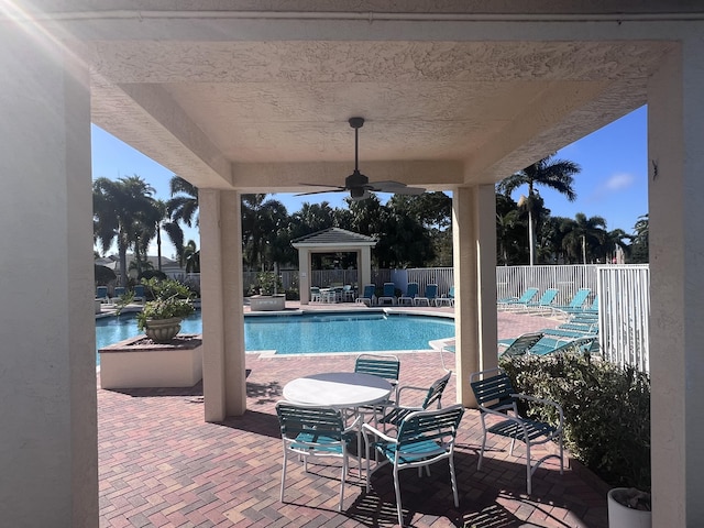 view of swimming pool with a patio area and ceiling fan