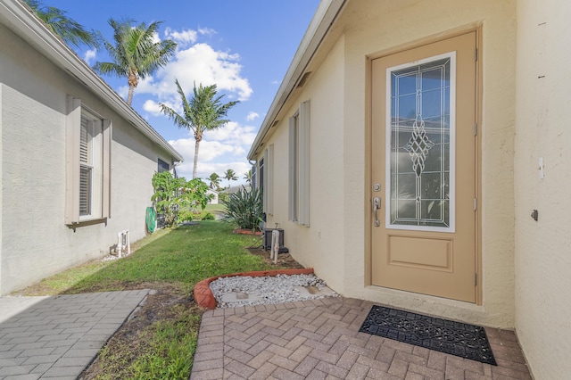 property entrance with a lawn