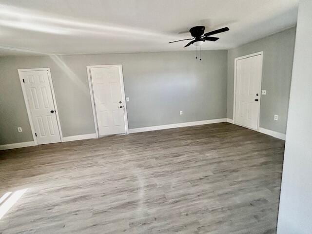 unfurnished room with ceiling fan, baseboards, and wood finished floors