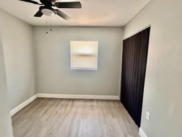 empty room with baseboards, ceiling fan, and wood finished floors