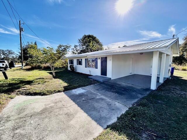 view of front of home featuring a front lawn and a carport