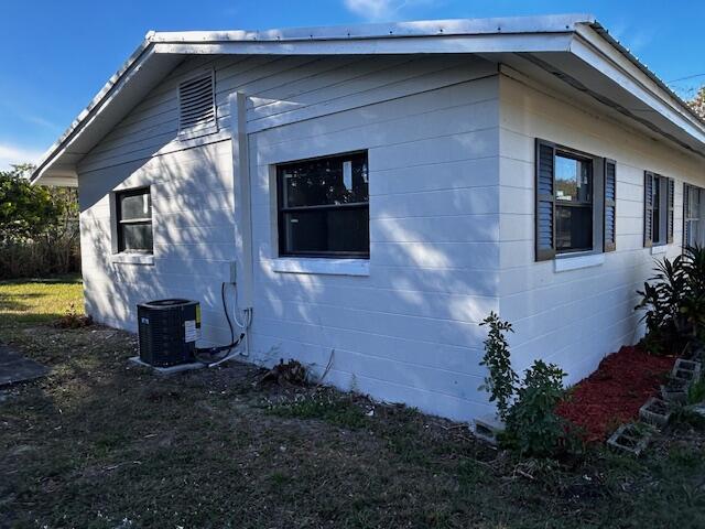 view of property exterior with central air condition unit and concrete block siding