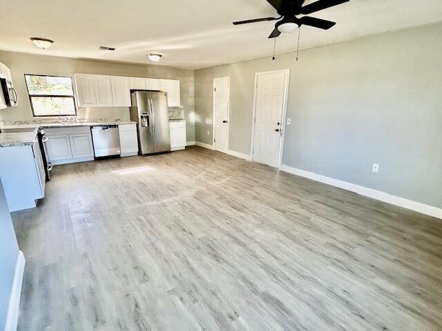 kitchen with white cabinetry, light hardwood / wood-style flooring, ceiling fan, and appliances with stainless steel finishes