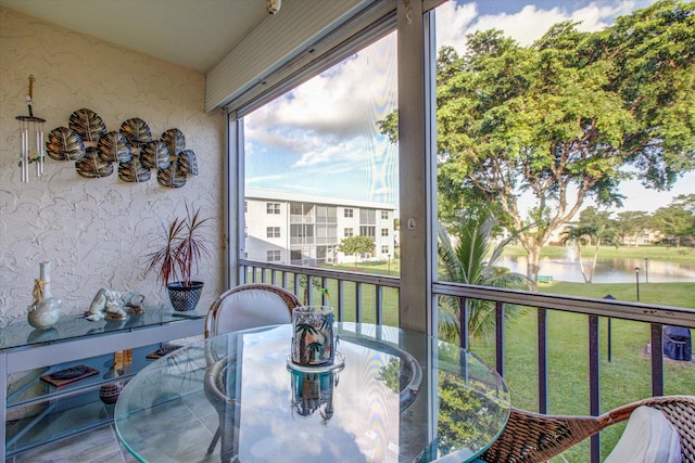 sunroom / solarium featuring a water view