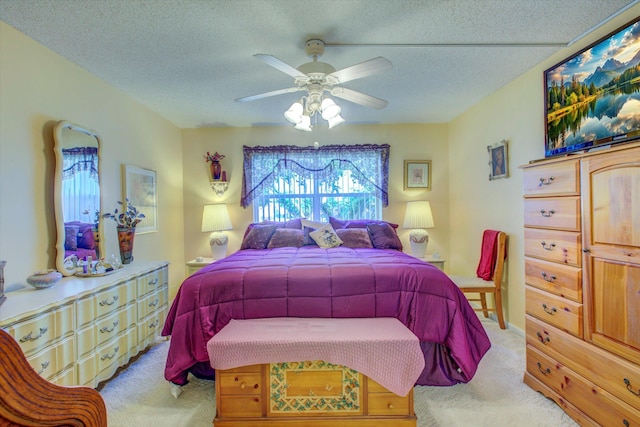 bedroom featuring light carpet, a textured ceiling, and ceiling fan