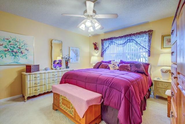 carpeted bedroom featuring ceiling fan and a textured ceiling