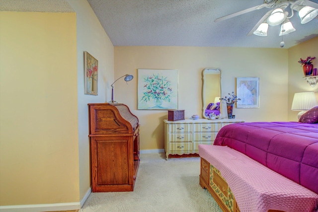 bedroom with a textured ceiling, ceiling fan, and light carpet