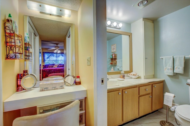 bathroom featuring toilet, a textured ceiling, tile patterned flooring, ceiling fan, and vanity