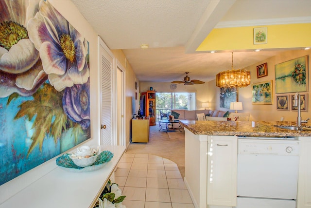 kitchen featuring white dishwasher, white cabinets, sink, and hanging light fixtures