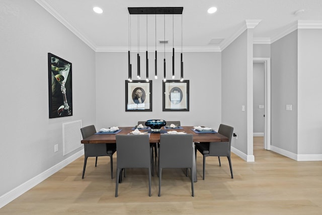 dining area featuring light hardwood / wood-style floors and crown molding