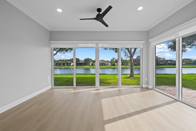 unfurnished sunroom with ceiling fan and a water view