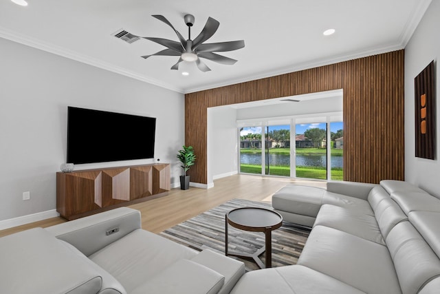 living room with hardwood / wood-style flooring, ceiling fan, and ornamental molding