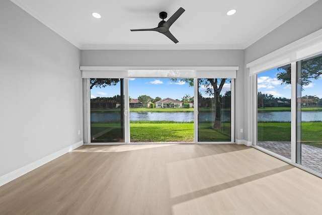 unfurnished sunroom featuring a water view and ceiling fan