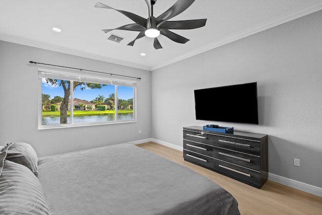 bedroom featuring ceiling fan, light hardwood / wood-style floors, and ornamental molding