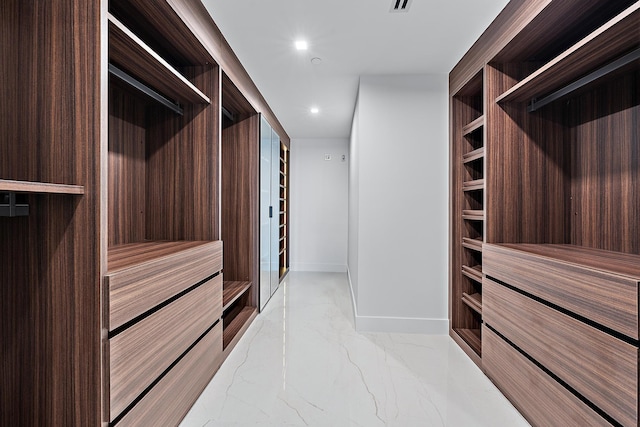 walk in closet featuring marble finish floor