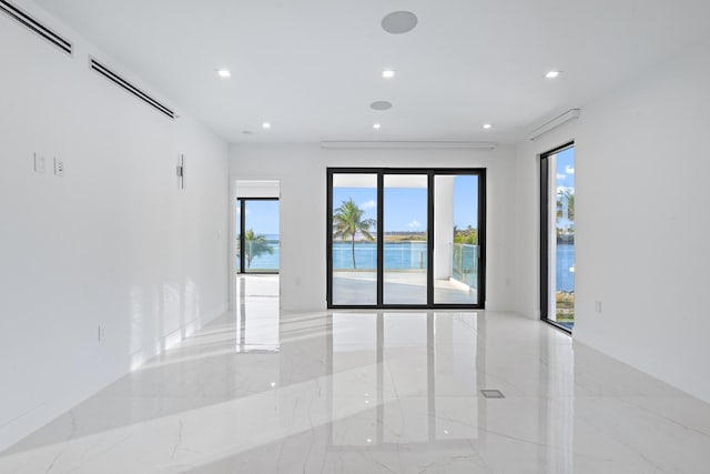 unfurnished room featuring a water view