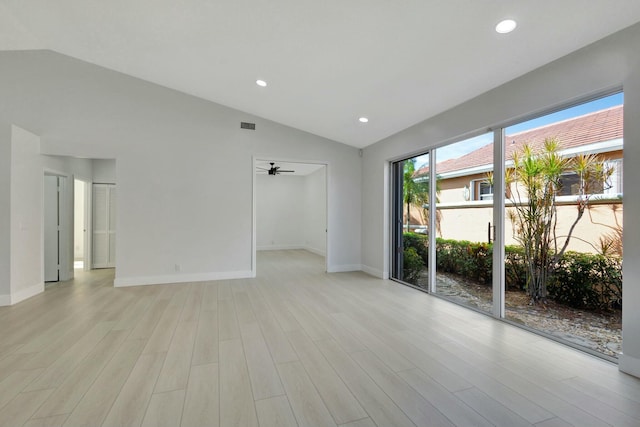 spare room featuring light wood-type flooring, ceiling fan, and lofted ceiling