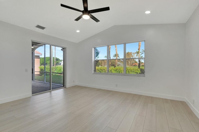 spare room with light wood-type flooring, vaulted ceiling, plenty of natural light, and ceiling fan