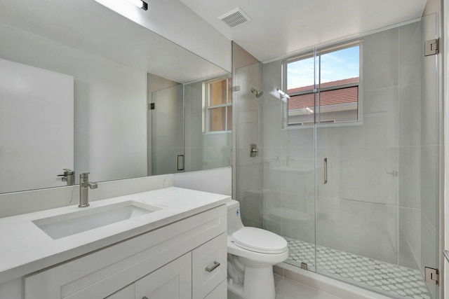 bathroom featuring tile patterned flooring, toilet, vanity, and walk in shower