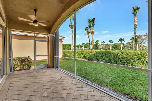 unfurnished sunroom with ceiling fan