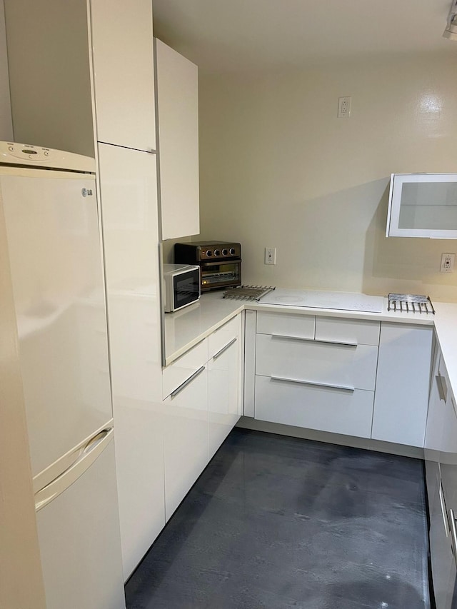 kitchen with white fridge and white cabinetry