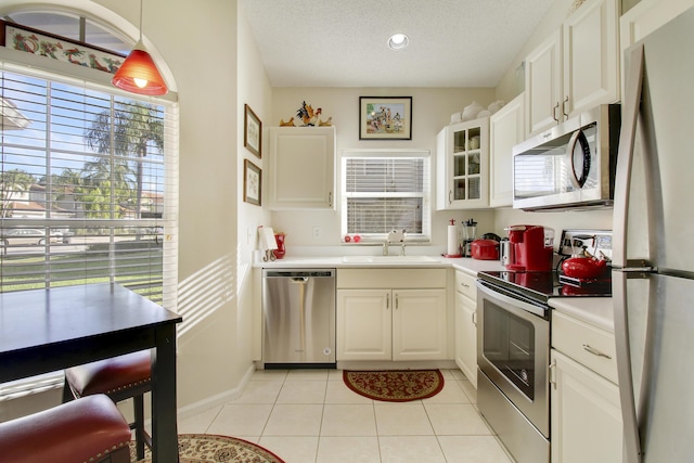 kitchen with white cabinetry, sink, decorative light fixtures, and appliances with stainless steel finishes