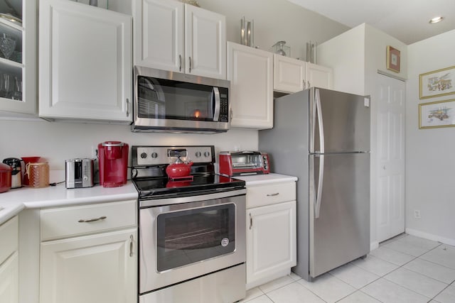 kitchen with light tile patterned floors, stainless steel appliances, and white cabinetry