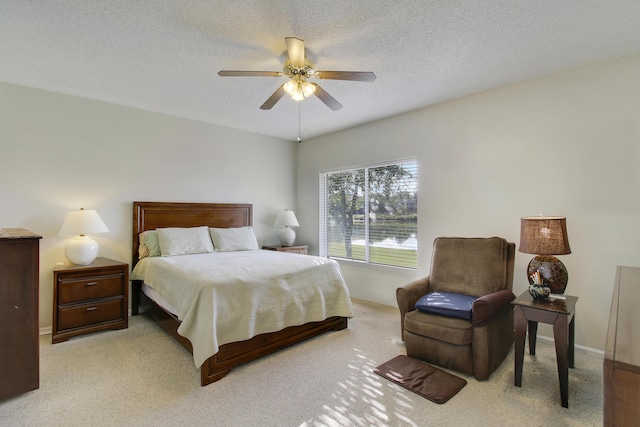 bedroom with light carpet, a textured ceiling, and ceiling fan