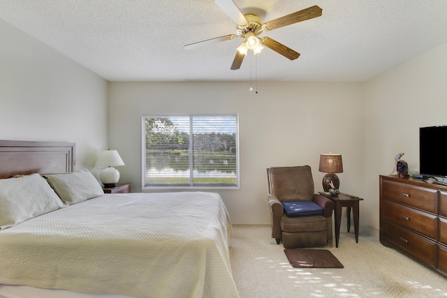 carpeted bedroom featuring a textured ceiling and ceiling fan