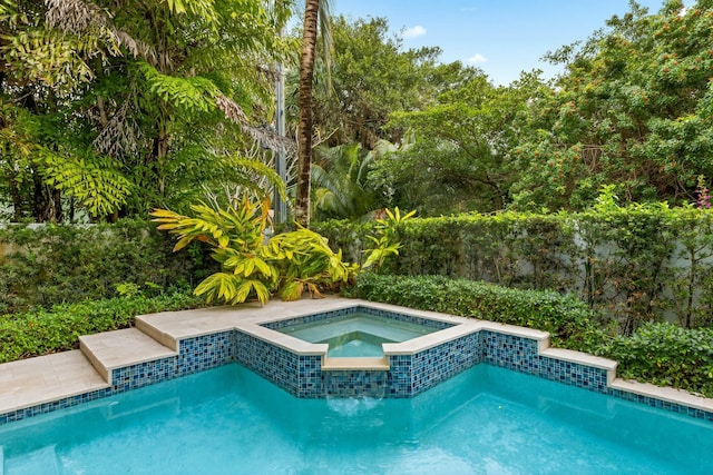 view of swimming pool with an in ground hot tub