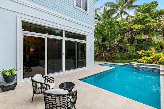 view of pool featuring an in ground hot tub and a patio