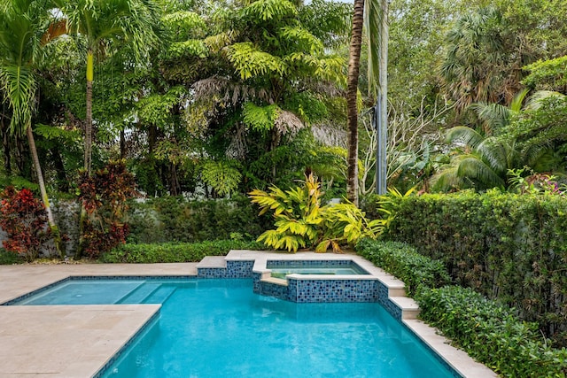 view of swimming pool with an in ground hot tub