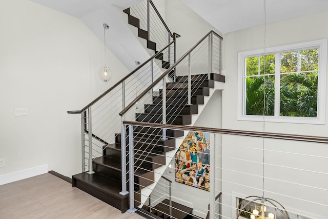 stairway featuring hardwood / wood-style flooring and vaulted ceiling